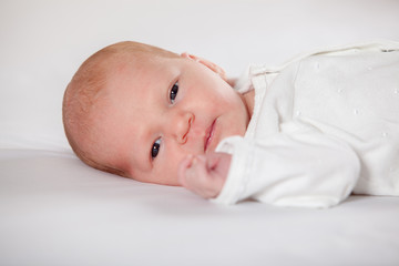 Newborn baby peacefully lying, on a white background