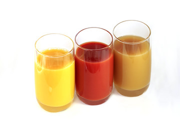 Three glasses with orange, tomato and Apple juice