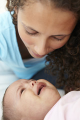 Worried Mother At Home With Crying Baby