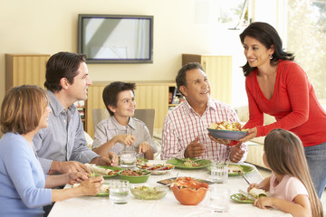 Extended Hispanic Family Enjoying Meal At Home