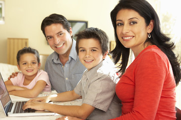 Fototapeta premium Young Hispanic Family Using Computer At Home