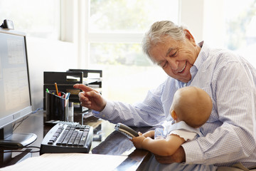 Senior Hispanic man with computer and baby