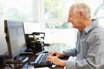 Senior man working on computer at home