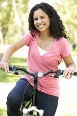 Obraz premium Young Hispanic Woman Cycling In Park