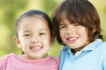 Hispanic Children Relaxing In Park