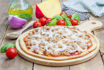 Pizza with tuna fish on a wooden board