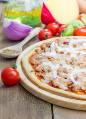 Pizza with tuna fish on a wooden board