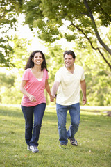 Obraz premium Young Hispanic Couple Running In Park