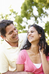 Romantic Young Hispanic Couple Relaxing In Park