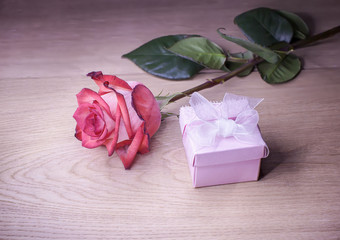 Beautiful rose and gift box on a wooden background