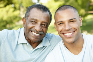 African American Father And Adult Son Relaxing In Park
