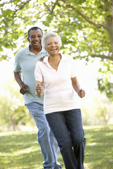 Senior African American Couple Running In Park