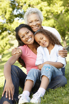 African American Grandmother, Mother And Daughter Relaxing In Park