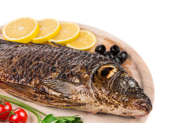 Fried carp on wooden platter.