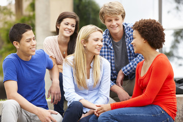 Multi racial student group sitting outdoors