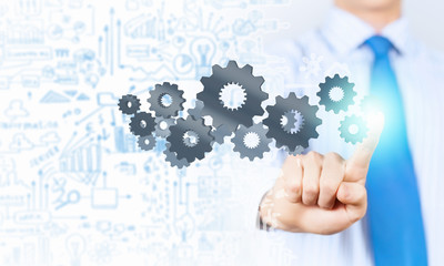 Businessman activating gears mechanism
