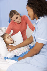 Obraz premium Nurse and mother at girl's bedside in hospital