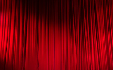 Red closed curtain with light spots in a theater
