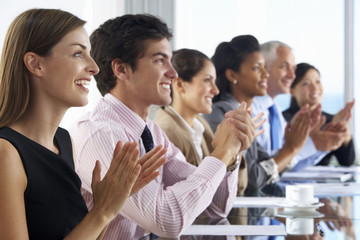 Fototapeta premium Line Of Business People Listening To Presentation Seated At Glass Boardroom Table