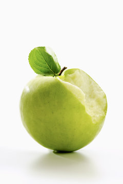 Angebissener Grüner Apfel  (Malus) mit Blättchen
