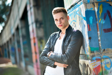 Male teenager leaning against a wall