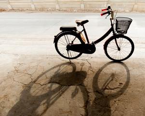Obraz premium Bicycle standing in the parking lot and its shadow