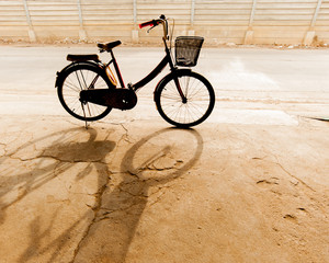 Fototapeta na wymiar Bicycle standing in the parking lot and its shadow