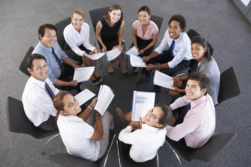 Fototapeta premium Overhead View Of Businesspeople Seated In Circle At Company Seminar