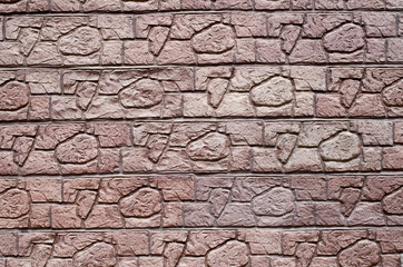 Red decorative relief plaster imitating stones on wall