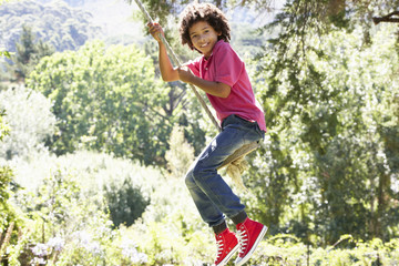 Young Boy Having Fun On Rope Swing