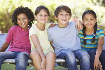 Group Of Children Sitting On Edge Of Trampoline Together