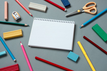 Fototapeta na wymiar Colorful School Supplies Scattered Around Notebook