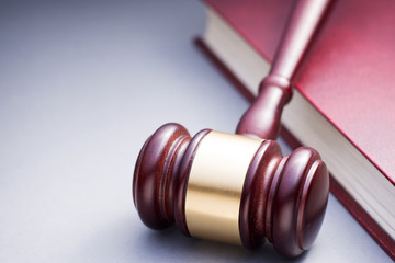 Wooden Gavel Resting on Red Leather Book