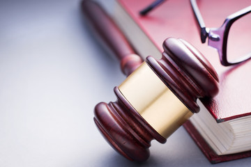 Wooden Gavel Resting on Red Leather Book