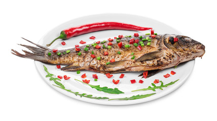Grilled carp with vegetables on plate.
