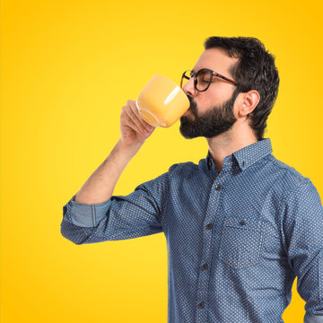 Young Hipster Man Drinking Coffee Over White Background