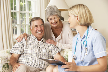 Retired Senior Man Having Health Check With Nurse At Home