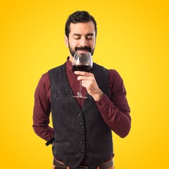 Man wearing waistcoat holding a wine glass