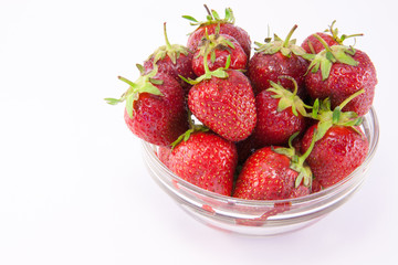 Transparent glass bowl with strawberries on white