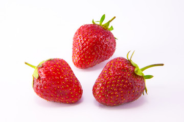 Transparent glass bowl with strawberries on white