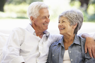 Senior Couple Relaxing On Sofa At Home