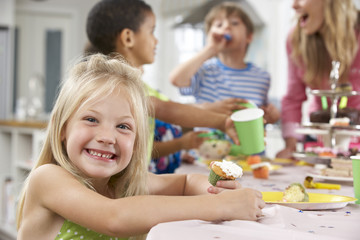 Obraz na płótnie Canvas Group Of Children Enjoying Birthday Party Food At Table