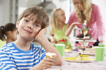 Obraz na płótnie Canvas Group Of Children Enjoying Birthday Party Food At Table