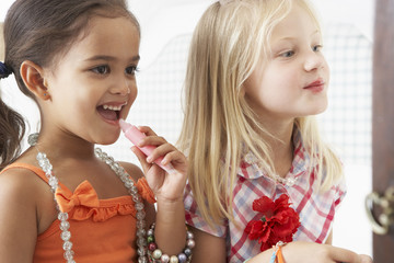 Two Young Girls Dressing Up And Putting On Make Up Together