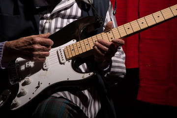 Funny elderly lady playing electric guitar.