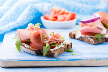 Open sandwiches with ham, tomato and arugula