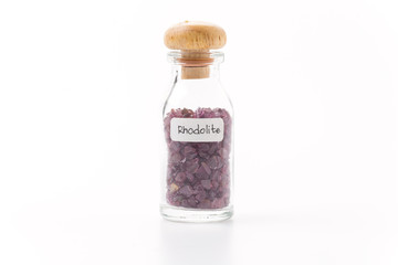rhodolite in glass bottle isolated on white background