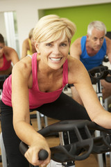 Woman Taking Part In Spinning Class In Gym