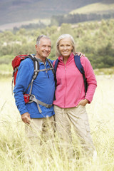 Naklejka na ściany i meble Senior Couple On Hike Through Beautiful Countryside