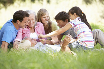 Fototapeta premium Three Generation Family Relaxing In Summer Field